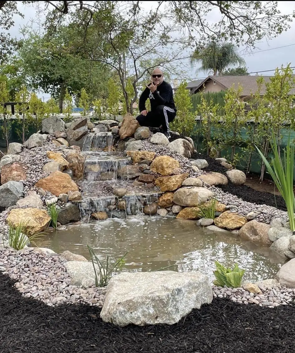 Dennis Kading beside a remodeled koi pond and waterfall in Upland, CA