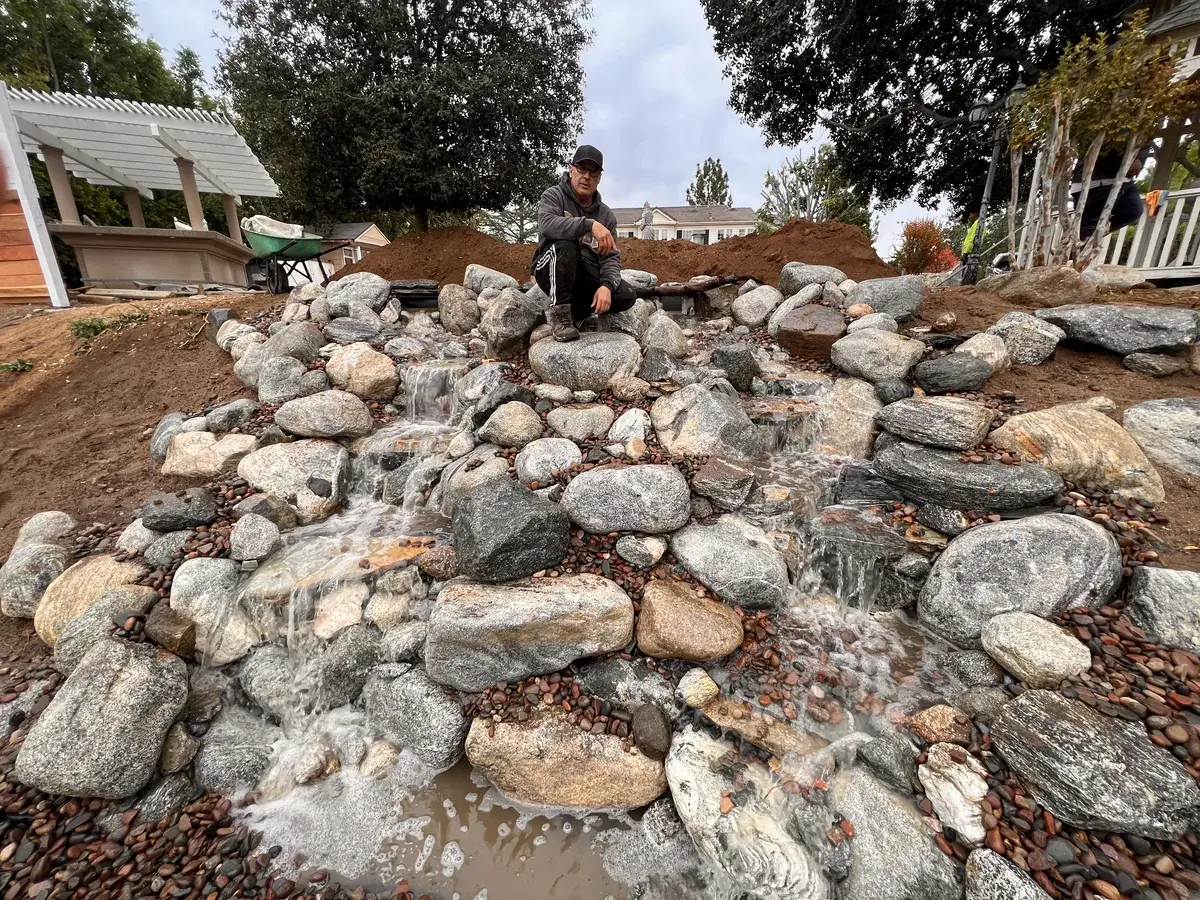 Dennis Kading resetting boulders along a stream during a repair