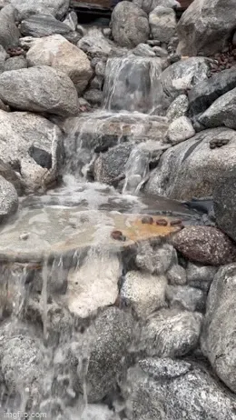 Pondless waterfall with three spillways flowing over boulders in Riverside, CA